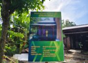 Baliho RTLH TMMD 128 Kodim Gresik telah Dipasang di Depan Rumah Ibu Eka Irawati